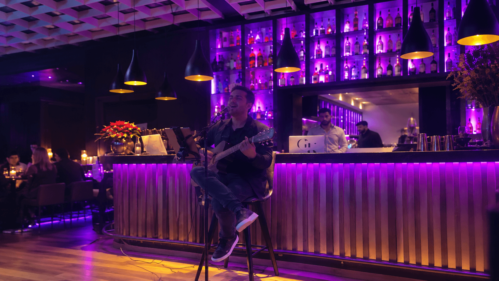 Sänger mit Gitarre vor der violett beleuchteten Bar des Âu Lac